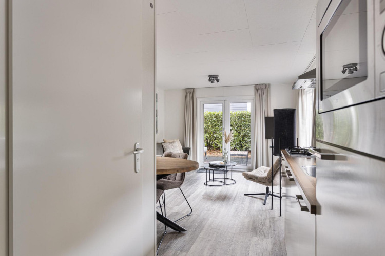 Modern two-person lodge at De Thijmse Berg, Netherlands, with cozy interior, kitchen, and garden access.