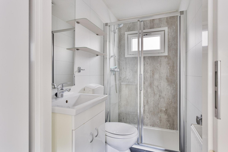 Modernes, kompaktes Badezimmer in der Wellness Lodge, De Thijmse Berg, Niederlande, mit Dusche und weißen Fliesen.