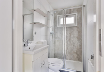 Baño moderno y compacto en Wellness Lodge, De Thijmse Berg, Países Bajos, con ducha y muebles blancos.