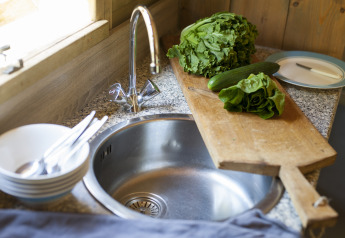 Keuken met verse sla, komkommer en snijplank in Camphome, Holiday park Witterzomer, Nederland.