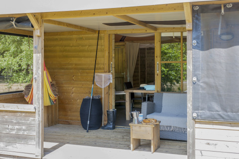 Buiten zithoek met sofa en tafel aan een Camphome op vakantiepark Witterzomer, Nederland.