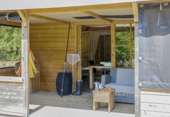Buiten zithoek met sofa en tafel aan een Camphome op vakantiepark Witterzomer, Nederland.