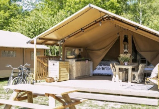 Safari-Zelt im Ferienpark Witterzomer in den Niederlanden, mit Terrasse, Fahrrädern und Picknicktisch.
