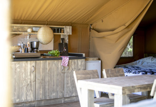 Intérieur de tente safari avec cuisine rustique et table au Holiday park Witterzomer, Pays-Bas.