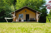 Tienda safari Villatent Nomad con hamaca y sillas en Vakantiepark de Twee Bruggen, Países Bajos.