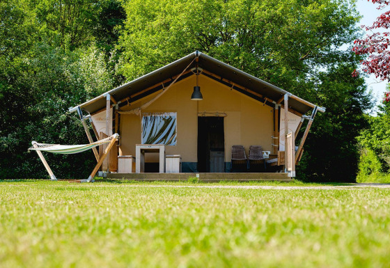 Tente safari Villatent Nomad avec hamac au Vakantiepark de Twee Bruggen aux Pays-Bas, sur une pelouse.