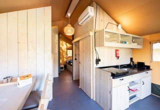 Vue intérieure d’une tente safari Villatent Nomad avec cuisine au Vakantiepark de Twee Bruggen, Pays-Bas.