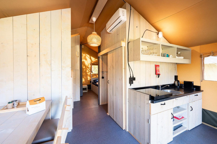 Vue intérieure d’une tente safari Villatent Nomad avec cuisine au Vakantiepark de Twee Bruggen, Pays-Bas.