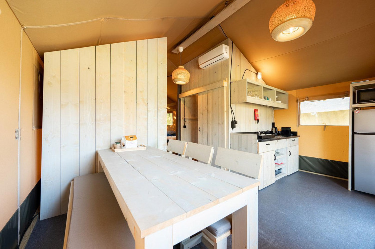 Interior view of a Villatent Nomad safari tent showing dining and kitchen area at Vakantiepark de Twee Bruggen.