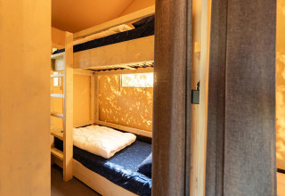 Letti a castello accoglienti in una tenda safari Villatent Nomad al Vakantiepark de Twee Bruggen, Paesi Bassi.