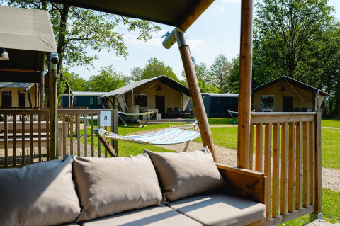 Tente safari Villatent Nomad avec terrasse, hamac et verdure au Vakantiepark de Twee Bruggen, Pays-Bas.