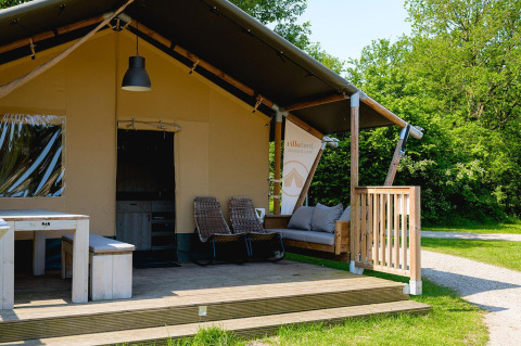 Tente safari Villatent Nomad au Vakantiepark de Twee Bruggen, Pays-Bas, avec terrasse et coin salon extérieur.
