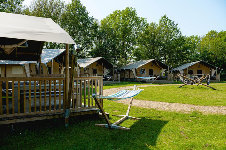 View of Villatent Nomad safari tents and hammocks at Vakantiepark de Twee Bruggen in the Netherlands.