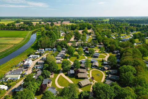 Vista aérea de tiendas safari y cabañas en Vakantiepark de Twee Bruggen, rodeadas de vegetación holandesa.