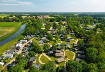 Vista aérea de tiendas safari y cabañas en Vakantiepark de Twee Bruggen, rodeadas de vegetación holandesa.