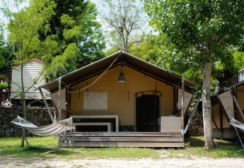 Safari-Zelt Villatent Wood auf dem Campingplatz Il Poggetto in Italien mit Veranda und Hängematte.