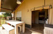 Tenda safari Villatent Wood con tavolo da pranzo in legno all’esterno e ingresso aperto all’interno.