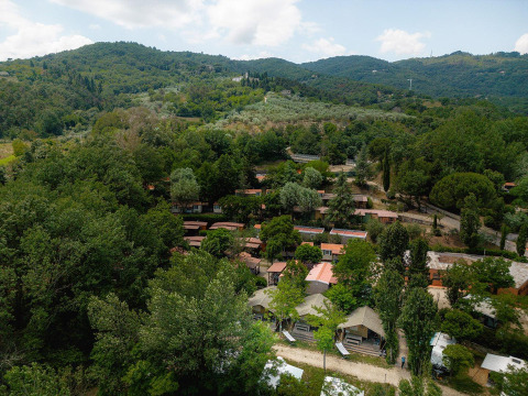 Vista aérea de las tiendas safari Villatent Wood en Camping Il Poggetto, rodeadas de colinas verdes en Italia.