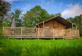 Safari Tent Wellness bij Vakantiepark Sallandshoeve in Nederland met houten veranda en groene omgeving.