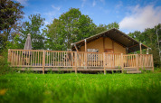 Safari Tent Wellness bij Vakantiepark Sallandshoeve in Nederland met houten veranda en groene omgeving.