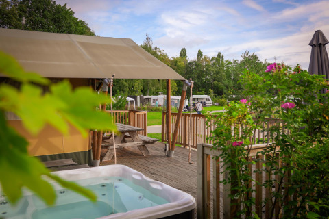 Tenda safari al Holiday Park Sallandshoeve nei Paesi Bassi con vasca idromassaggio e terrazza in legno.