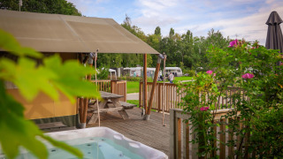 Tente safari au Holiday Park Sallandshoeve aux Pays-Bas, avec spa extérieur et terrasse en bois.