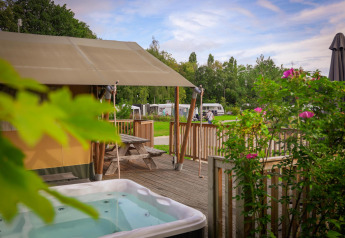 Safari telt ved Holiday Park Sallandshoeve i Holland med trædæk, boblebad og grønne omgivelser.