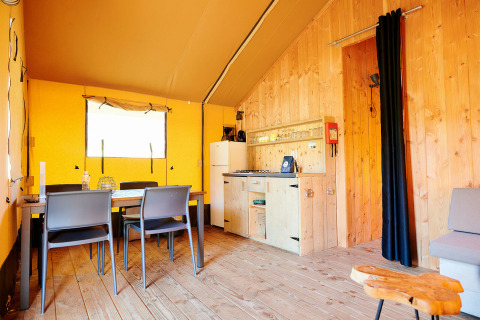 Vue intérieure de la tente Safari Wellness au Holiday Park Sallandshoeve avec table à manger et kitchenette.
