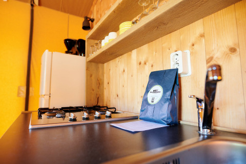 Cocina moderna en una tienda safari en Holiday Park Sallandshoeve, Países Bajos, con estufa de gas y fregadero.
