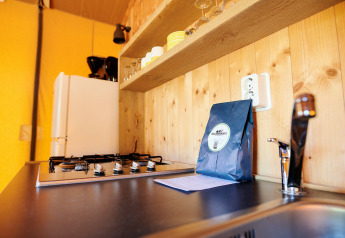 Moderne keuken in een safaritent bij Holiday Park Sallandshoeve in Nederland met gaskookplaat en spoelbak.