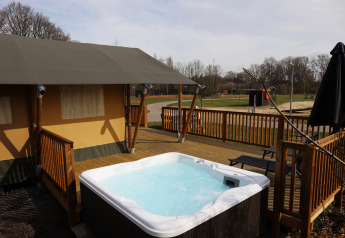 Tente safari avec jacuzzi sur terrasse en bois au Holiday Park Sallandshoeve aux Pays-Bas.