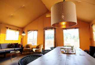 Vista interior de una tienda Safari Cottage XL en Holiday Park Sallandshoeve, Países Bajos, con decoración moderna.