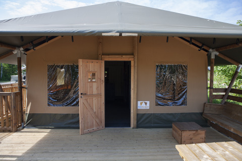 Vista exterior de una tienda Safaricottage XL con terraza de madera en Holiday Park Sallandshoeve.
