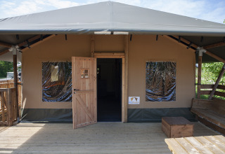 Buitenzicht van een Safaricottage XL safaritent met houten terras in Holiday Park Sallandshoeve.