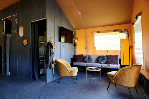 Salon d'une tente Safaricottage XL au Holiday Park Sallandshoeve, Pays-Bas, avec décoration contemporaine.