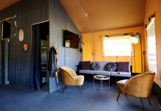 Indretning af stue i en Safaricottage XL telt på Holiday Park Sallandshoeve, Holland, med moderne møbler.
