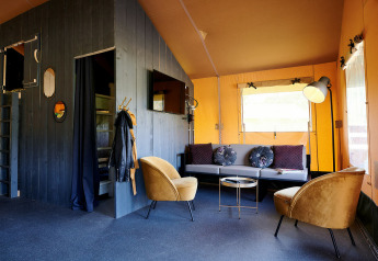 Indretning af stue i en Safaricottage XL telt på Holiday Park Sallandshoeve, Holland, med moderne møbler.
