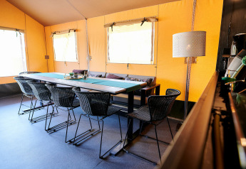 Interieur van Safaricottage XL op Holiday Park Sallandshoeve met eettafel en moderne stoelen.