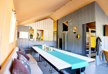 Interieur van Safaricottage XL safaritent bij Holiday Park Sallandshoeve in Nederland met eethoek en keuken.