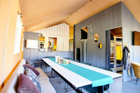 Interiør af Safaricottage XL telt ved Holiday Park Sallandshoeve i Nederlandene med spisebord og køkken.