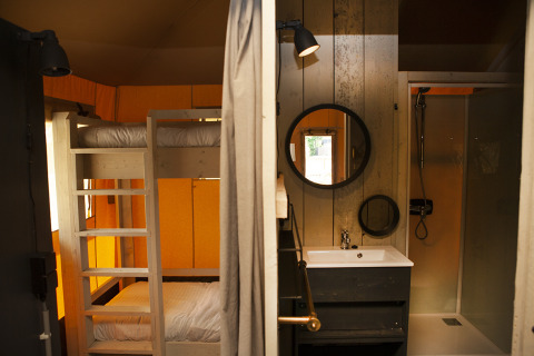 Intérieur du Safaricottage XL avec lits superposés et salle de bain à Holiday Park Sallandshoeve, Pays-Bas.
