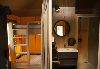 Interieur van Safaricottage XL met stapelbed en badkamer in Holiday Park Sallandshoeve, Nederland.