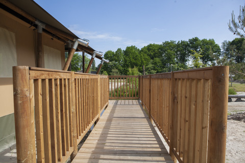 Rampe et balustrade en bois menant à une tente safari au Holiday Park Sallandshoeve, aux Pays-Bas, l’été.