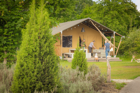 Famille profite du plein air devant une tente safari au Holiday Park Sallandshoeve aux Pays-Bas.
