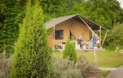 Famille profite du plein air devant une tente safari au Holiday Park Sallandshoeve aux Pays-Bas.