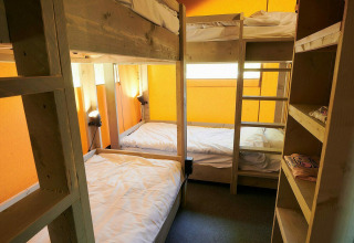 Interieur van safaritent met stapelbedden en planken bij Holiday Park Sallandshoeve, Nederland, zonnig licht.