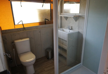 Badkamer in safaritent op Holiday Park Sallandshoeve in Nederland met toilet, wastafel en douche.