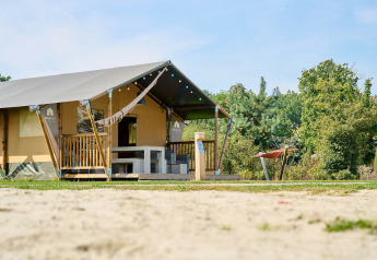 Tente safari au Holiday Park Sallandshoeve aux Pays-Bas, avec terrasse et hamac en pleine verdure.