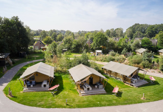 Luksuriøse safaritelt ved Holiday Park Sallandshoeve i Holland, omgivet af grønt og solrigt vejr.
