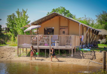 Niños juegan junto al agua frente a una tienda safari de lujo en Holiday Park Sallandshoeve, Países Bajos.